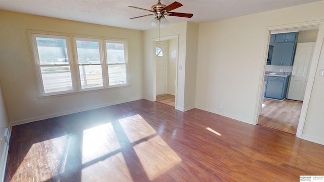 unfurnished living room with hardwood / wood-style floors and ceiling fan