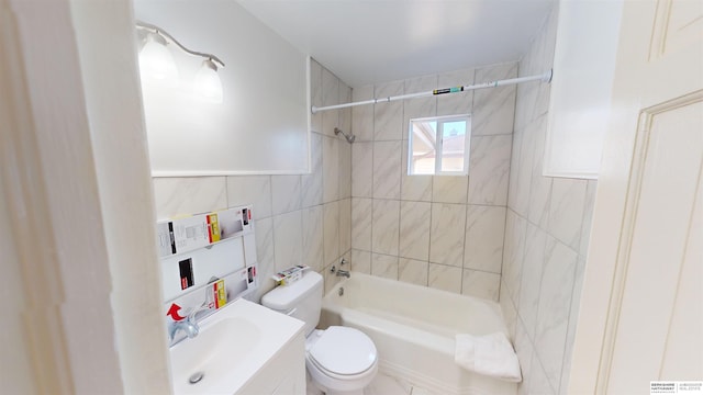 full bathroom featuring vanity, tiled shower / bath combo, tile walls, and toilet