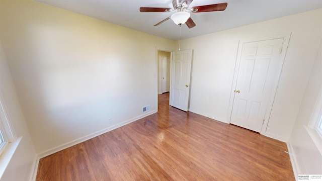 unfurnished bedroom with ceiling fan and light wood-type flooring