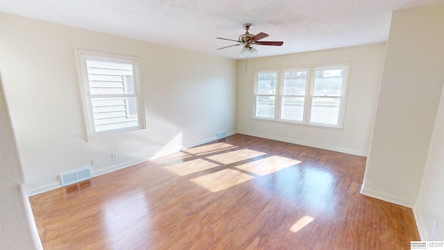 unfurnished room featuring hardwood / wood-style flooring, ceiling fan, and a textured ceiling