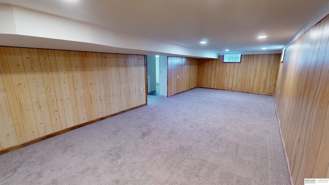 basement featuring wood walls and light colored carpet