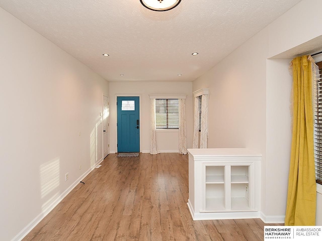 foyer with light hardwood / wood-style floors and a textured ceiling