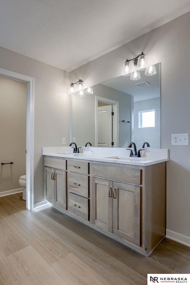 bathroom featuring hardwood / wood-style flooring, vanity, and toilet