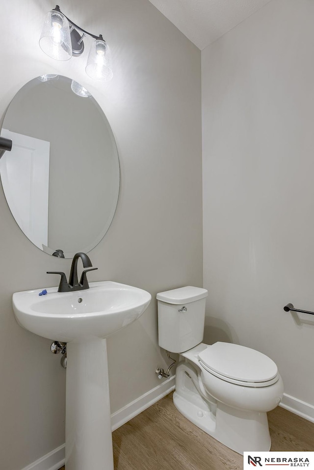 bathroom featuring hardwood / wood-style flooring and toilet