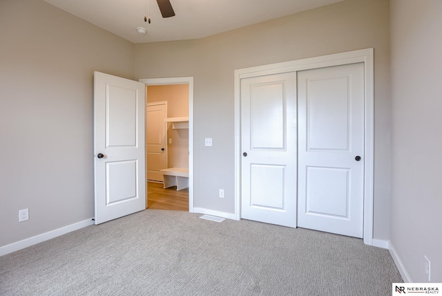 unfurnished bedroom with light carpet, a closet, and ceiling fan