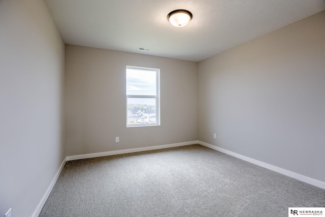 spare room featuring carpet and a textured ceiling