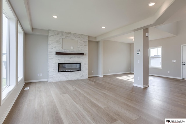 unfurnished living room featuring a fireplace and light hardwood / wood-style floors