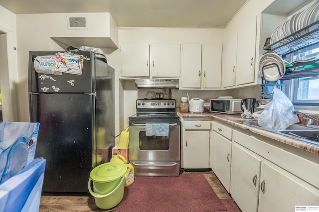 kitchen with black fridge, stainless steel electric stove, dark wood-type flooring, sink, and white cabinets