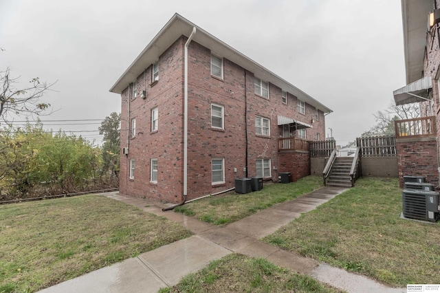 view of side of home with a yard, central AC unit, and a deck