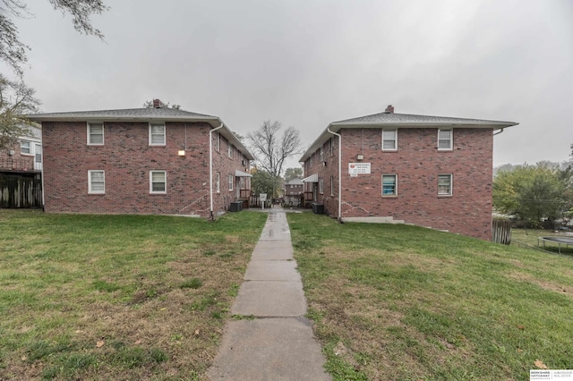 view of side of property with a lawn and central air condition unit