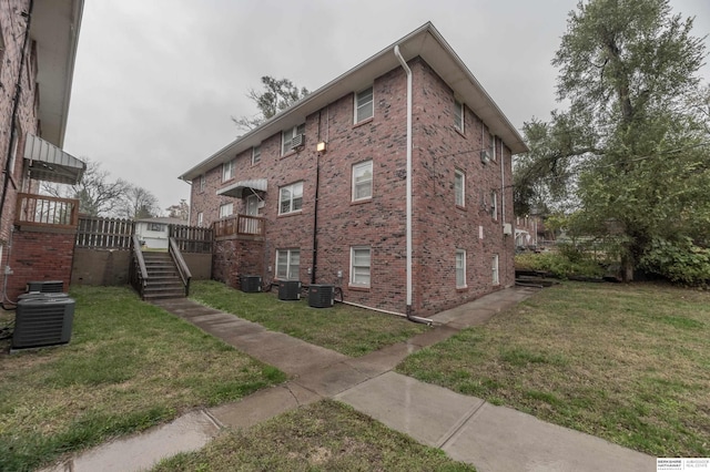 view of side of home with a yard and central air condition unit