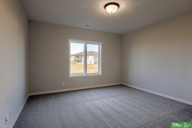 carpeted spare room with a textured ceiling