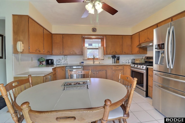 kitchen featuring ceiling fan, sink, stainless steel appliances, decorative backsplash, and light tile patterned floors