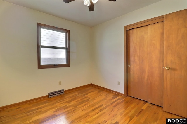 unfurnished bedroom with ceiling fan, light wood-type flooring, and a closet