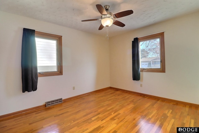 empty room with light hardwood / wood-style flooring and ceiling fan