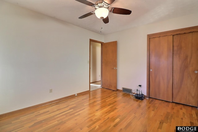 unfurnished bedroom featuring ceiling fan, a closet, and light wood-type flooring