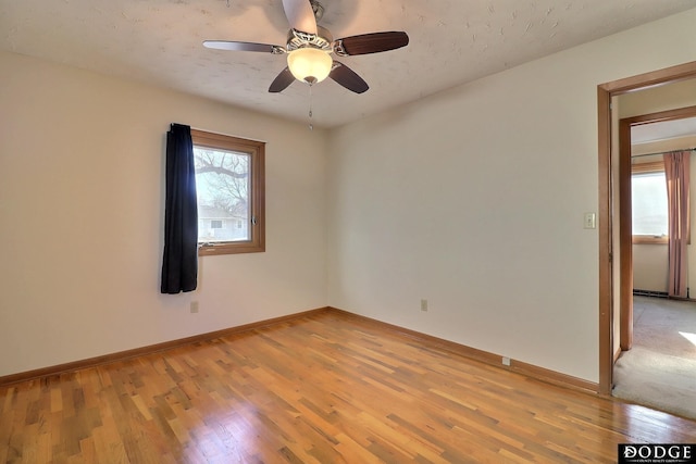 empty room with light hardwood / wood-style flooring and ceiling fan