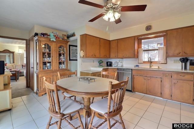 kitchen featuring dishwasher, light tile patterned flooring, ceiling fan, and sink