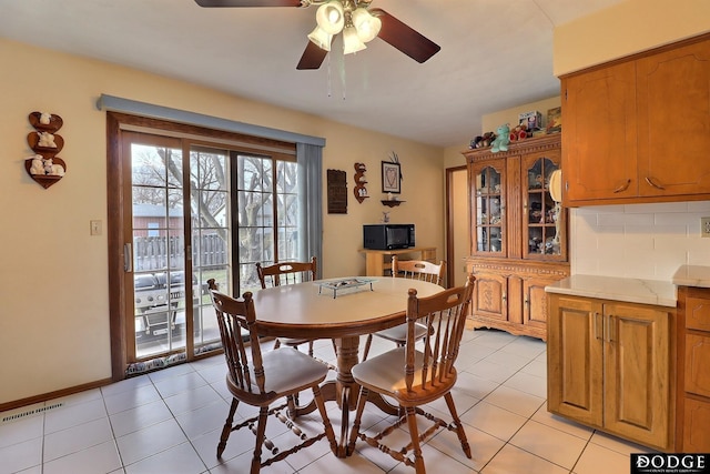 dining space featuring ceiling fan and light tile patterned floors