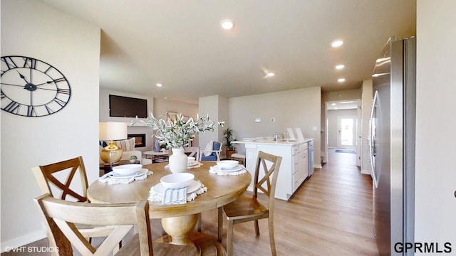 dining space featuring light wood-type flooring and sink