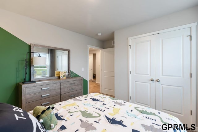 bedroom with light hardwood / wood-style flooring and a closet