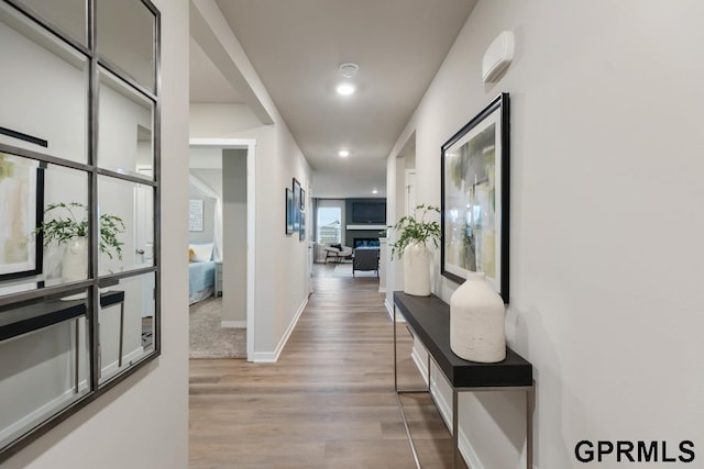 corridor with light hardwood / wood-style floors