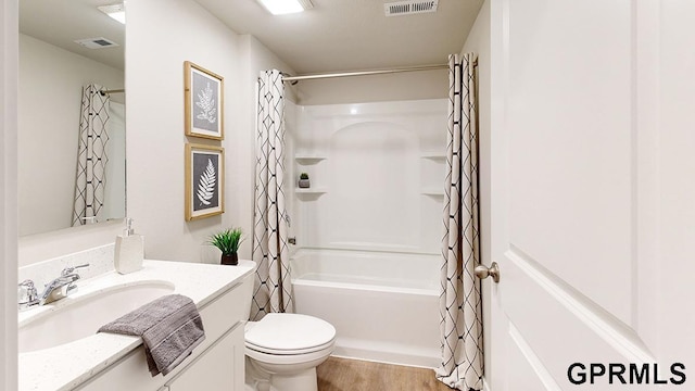 full bathroom featuring hardwood / wood-style floors, vanity, toilet, and shower / tub combo with curtain