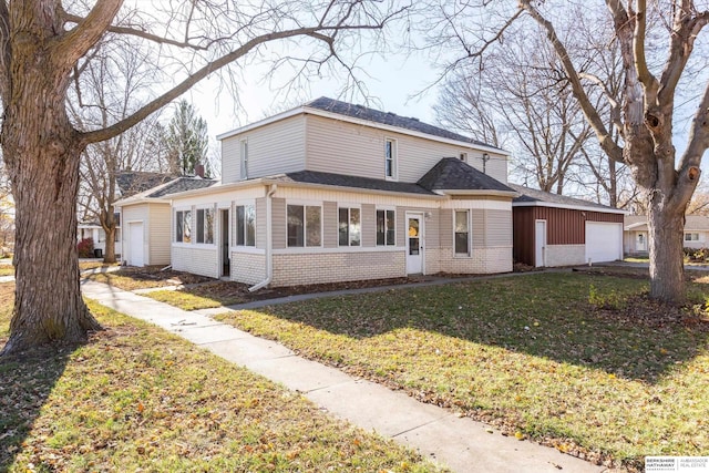 view of front facade featuring a garage, a front lawn, and a sunroom