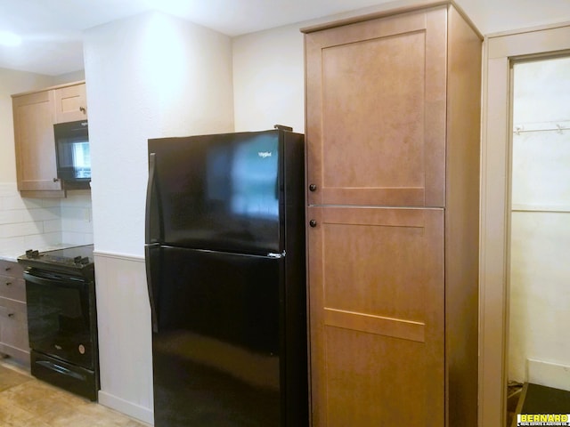 kitchen featuring light brown cabinetry, tasteful backsplash, and black appliances