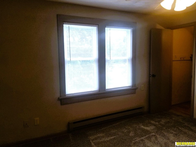 spare room featuring baseboard heating, ceiling fan, and dark carpet