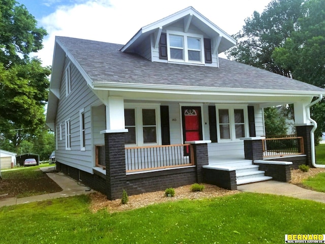 view of front of property featuring covered porch and a front yard