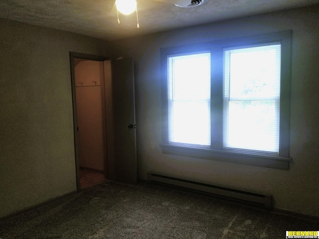 unfurnished room featuring carpet floors, plenty of natural light, and a baseboard heating unit