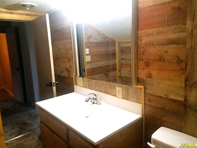 bathroom featuring tile patterned flooring, vanity, a textured ceiling, and toilet