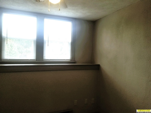 spare room featuring ceiling fan and a textured ceiling