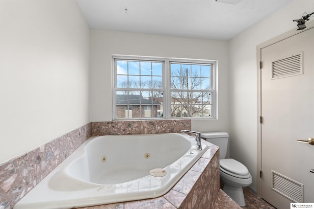 bathroom with toilet and tiled bath