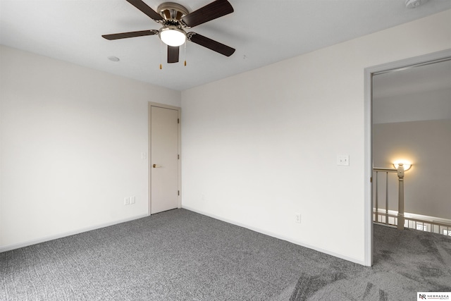 empty room featuring ceiling fan and carpet