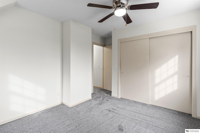 unfurnished bedroom with ceiling fan, light colored carpet, and a closet