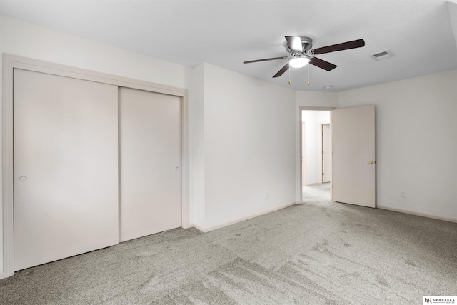 unfurnished bedroom featuring ceiling fan, a closet, and carpet