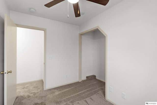 carpeted spare room featuring ceiling fan