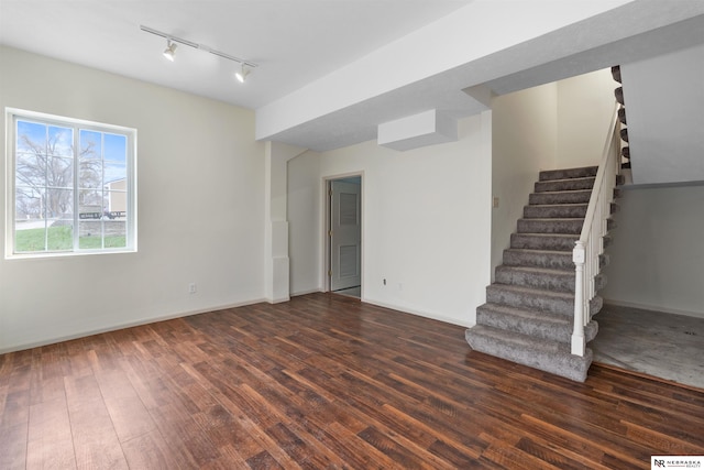 unfurnished room featuring rail lighting and dark hardwood / wood-style floors