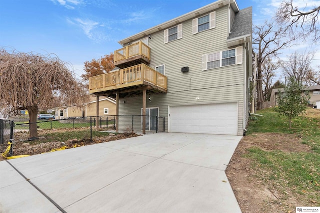 rear view of property featuring a balcony and a garage