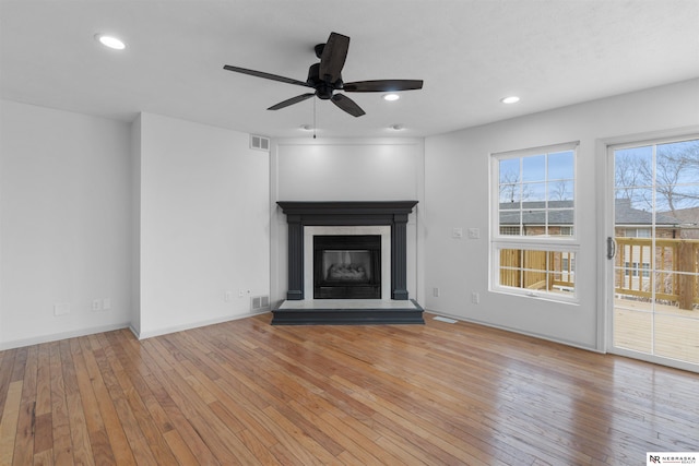 unfurnished living room featuring ceiling fan and light hardwood / wood-style flooring