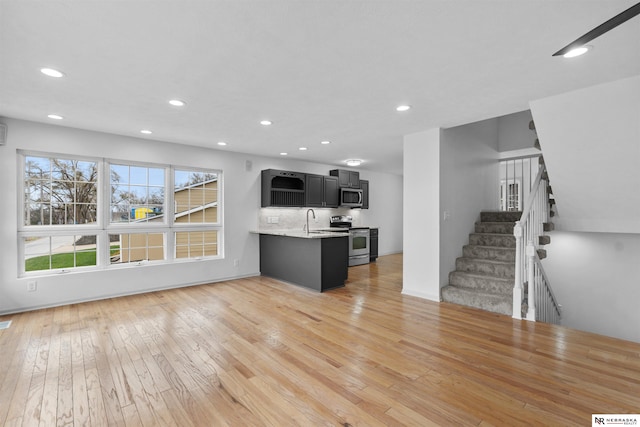 unfurnished living room with sink and light hardwood / wood-style flooring