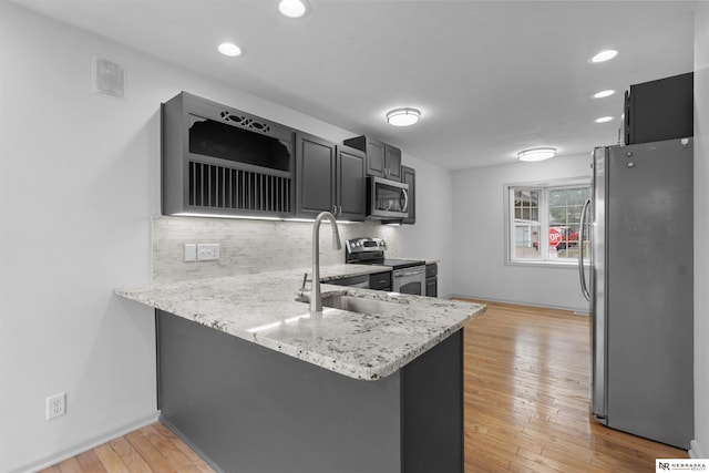 kitchen featuring light hardwood / wood-style floors, kitchen peninsula, and stainless steel appliances