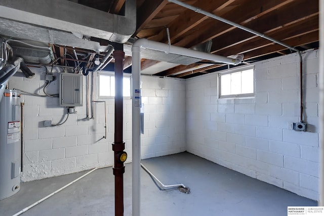 basement featuring electric water heater, electric panel, and a wealth of natural light