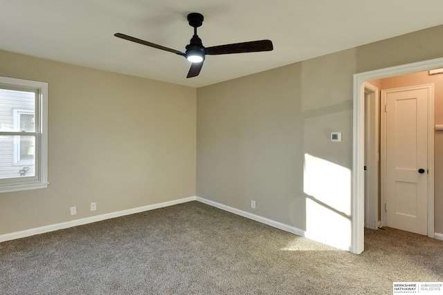 carpeted spare room with ceiling fan