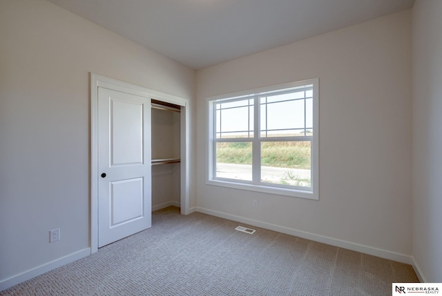 unfurnished bedroom featuring carpet flooring, visible vents, and baseboards