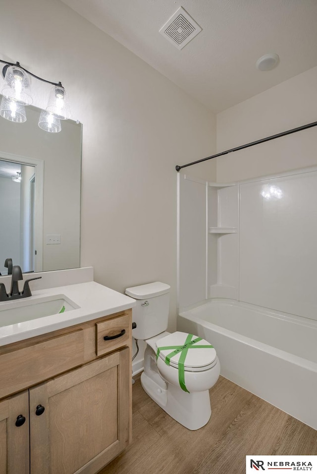 full bathroom featuring visible vents, toilet, shower / tub combination, wood finished floors, and vanity