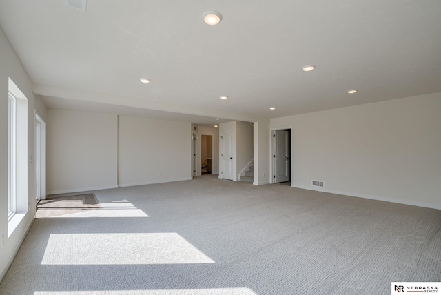 empty room with light carpet, baseboards, visible vents, stairs, and recessed lighting