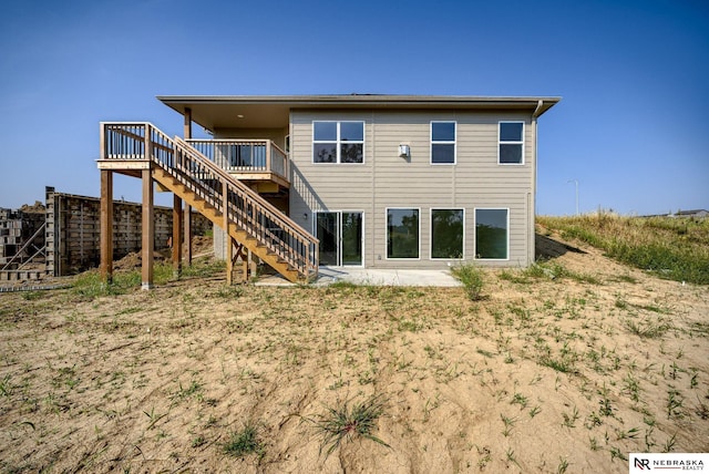 rear view of house with stairway and a deck